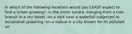 In which of the following locations would you LEAST expect to find a lichen growing? -in the Arctic tundra -hanging from a tree branch in a dry forest -on a rock near a waterfall subjected to occasional splashing -on a statue in a city known for its polluted air