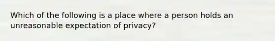 Which of the following is a place where a person holds an unreasonable expectation of privacy?