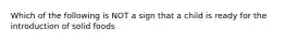 Which of the following is NOT a sign that a child is ready for the introduction of solid foods