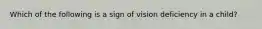 Which of the following is a sign of vision deficiency in a child?