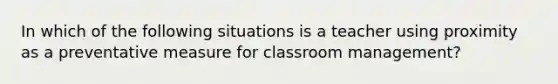 In which of the following situations is a teacher using proximity as a preventative measure for classroom management?