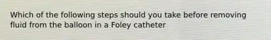 Which of the following steps should you take before removing fluid from the balloon in a Foley catheter