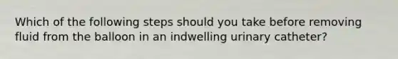 Which of the following steps should you take before removing fluid from the balloon in an indwelling urinary catheter?