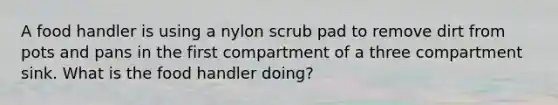 A food handler is using a nylon scrub pad to remove dirt from pots and pans in the first compartment of a three compartment sink. What is the food handler doing?