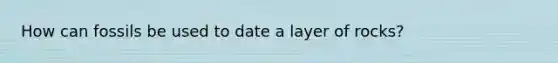 How can fossils be used to date a layer of rocks?