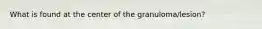What is found at the center of the granuloma/lesion?