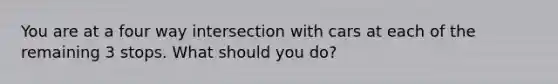 You are at a four way intersection with cars at each of the remaining 3 stops. What should you do?