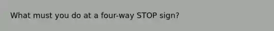 What must you do at a four-way STOP sign?