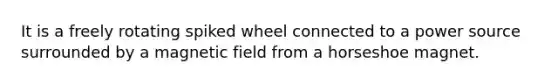 It is a freely rotating spiked wheel connected to a power source surrounded by a magnetic field from a horseshoe magnet.