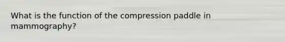 What is the function of the compression paddle in mammography?