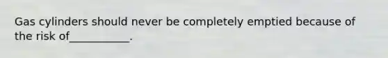 Gas cylinders should never be completely emptied because of the risk of___________.