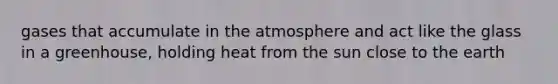 gases that accumulate in the atmosphere and act like the glass in a greenhouse, holding heat from the sun close to the earth