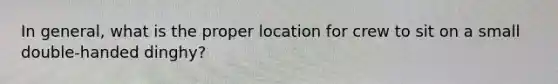 In general, what is the proper location for crew to sit on a small double-handed dinghy?