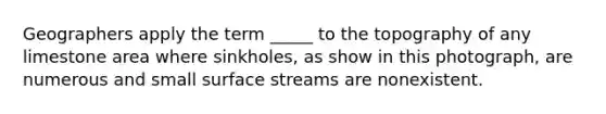 Geographers apply the term _____ to the topography of any limestone area where sinkholes, as show in this photograph, are numerous and small surface streams are nonexistent.