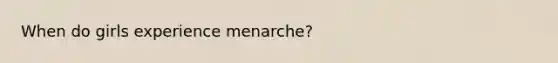 When do girls experience menarche?