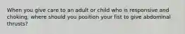 When you give care to an adult or child who is responsive and choking, where should you position your fist to give abdominal thrusts?