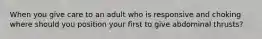 When you give care to an adult who is responsive and choking where should you position your first to give abdominal thrusts?