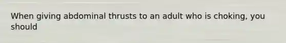 When giving abdominal thrusts to an adult who is choking, you should