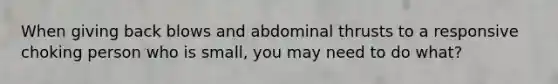 When giving back blows and abdominal thrusts to a responsive choking person who is small, you may need to do what?