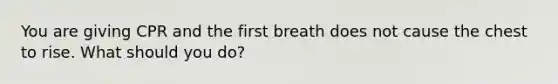 You are giving CPR and the first breath does not cause the chest to rise. What should you do?