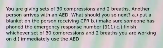 You are giving sets of 30 compressions and 2 breaths. Another person arrives with an AED. What should you so next? a.) put a blanket on the person receiving CPR b.) make sure someone has phoned the emergency response number (911) c.) finish whichever set of 30 compressions and 2 breaths you are working on d.) immediately use the AED