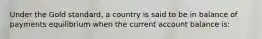 Under the Gold standard, a country is said to be in balance of payments equilibrium when the current account balance is: