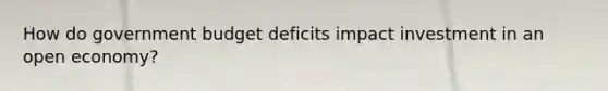 How do government budget deficits impact investment in an open economy?