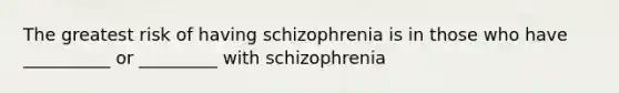 The greatest risk of having schizophrenia is in those who have __________ or _________ with schizophrenia