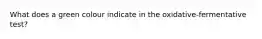What does a green colour indicate in the oxidative-fermentative test?