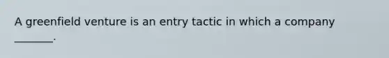 A greenfield venture is an entry tactic in which a company _______.