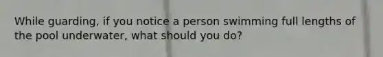 While guarding, if you notice a person swimming full lengths of the pool underwater, what should you do?