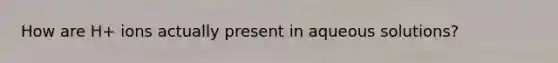 How are H+ ions actually present in aqueous solutions?