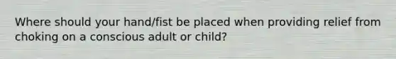 Where should your hand/fist be placed when providing relief from choking on a conscious adult or child?