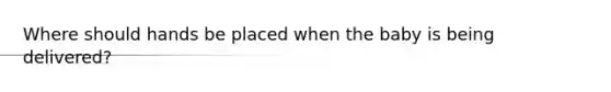 Where should hands be placed when the baby is being delivered?