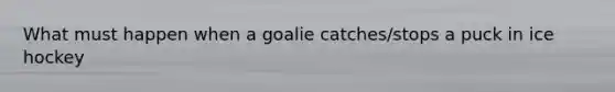 What must happen when a goalie catches/stops a puck in ice hockey