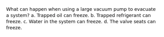 What can happen when using a large vacuum pump to evacuate a system? a. Trapped oil can freeze. b. Trapped refrigerant can freeze. c. Water in the system can freeze. d. The valve seats can freeze.