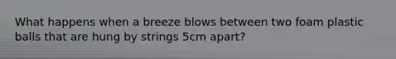 What happens when a breeze blows between two foam plastic balls that are hung by strings 5cm apart?