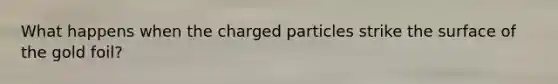 What happens when the charged particles strike the surface of the gold foil?