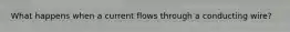 What happens when a current flows through a conducting wire?