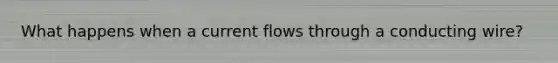 What happens when a current flows through a conducting wire?