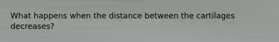 What happens when the distance between the cartilages decreases?