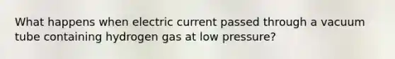 What happens when electric current passed through a vacuum tube containing hydrogen gas at low pressure?