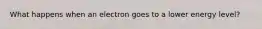 What happens when an electron goes to a lower energy level?