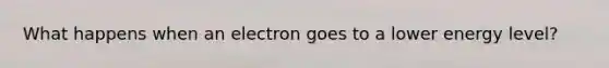 What happens when an electron goes to a lower energy level?
