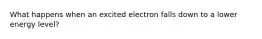 What happens when an excited electron falls down to a lower energy level?