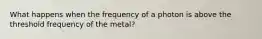 What happens when the frequency of a photon is above the threshold frequency of the metal?