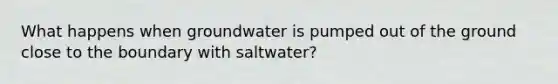 What happens when groundwater is pumped out of the ground close to the boundary with saltwater?