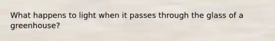 What happens to light when it passes through the glass of a greenhouse?