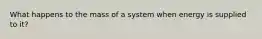 What happens to the mass of a system when energy is supplied to it?