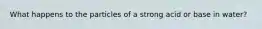 What happens to the particles of a strong acid or base in water?